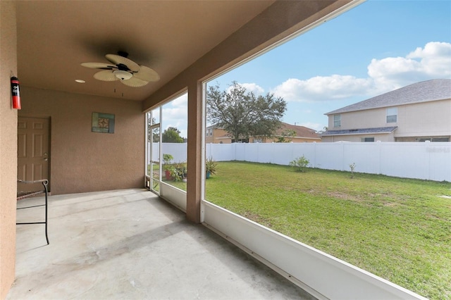 unfurnished sunroom with ceiling fan