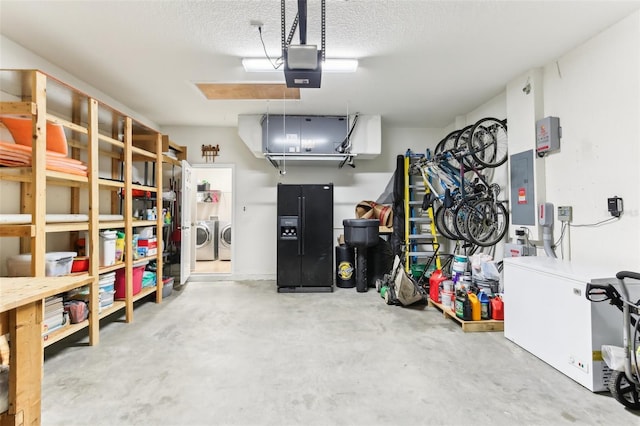 garage with a garage door opener, separate washer and dryer, and electric panel