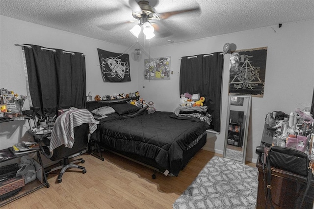 bedroom with ceiling fan, light hardwood / wood-style floors, and a textured ceiling