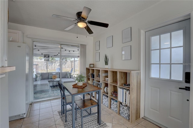 dining room featuring light tile patterned flooring, ceiling fan, and a textured ceiling