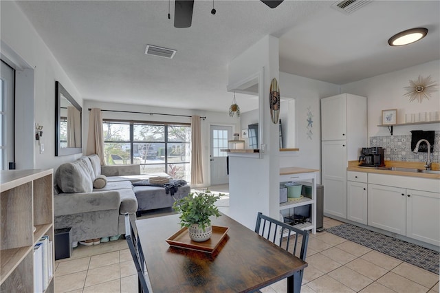 dining room with light tile patterned flooring, ceiling fan, and sink