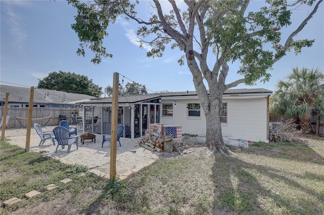 back of house with an outdoor fire pit, a yard, and a patio area