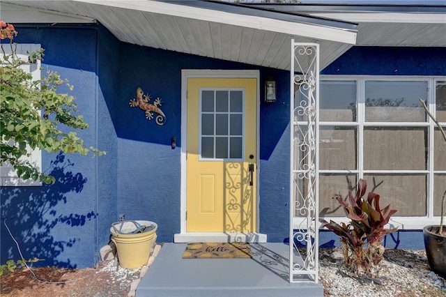 view of exterior entry with stucco siding