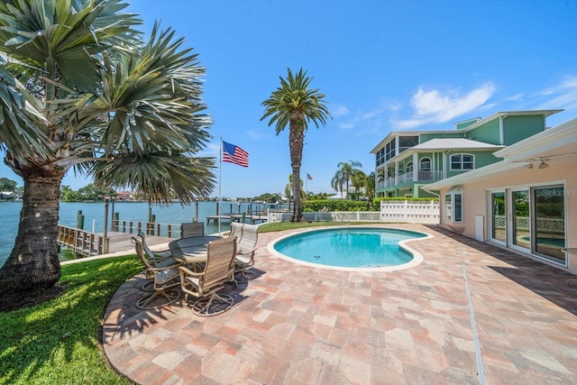 view of swimming pool featuring a patio area and a water view