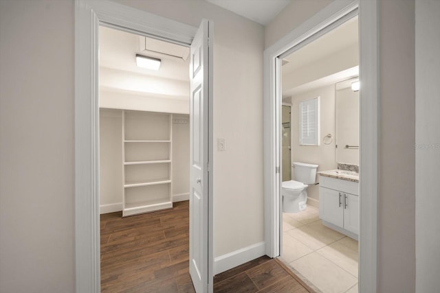 bathroom with wood-type flooring, toilet, and vanity