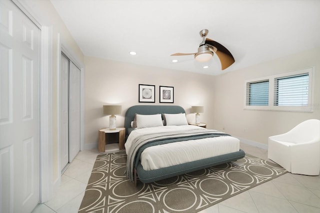 tiled bedroom with ceiling fan and a closet