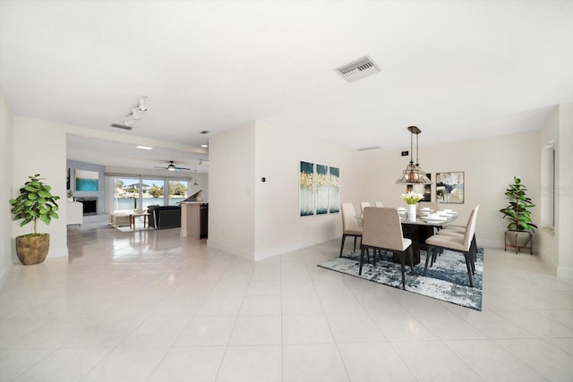 tiled dining area with rail lighting and ceiling fan