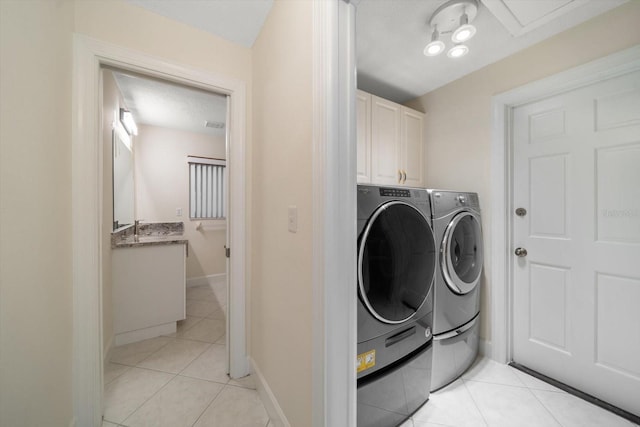 laundry room featuring light tile patterned floors, sink, cabinets, and independent washer and dryer