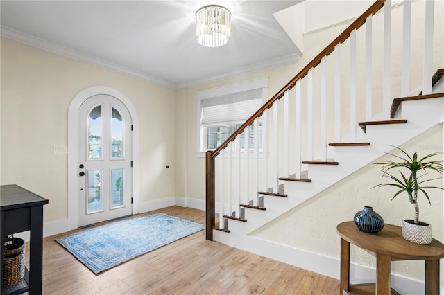 foyer featuring ornamental molding, a notable chandelier, and light hardwood / wood-style floors