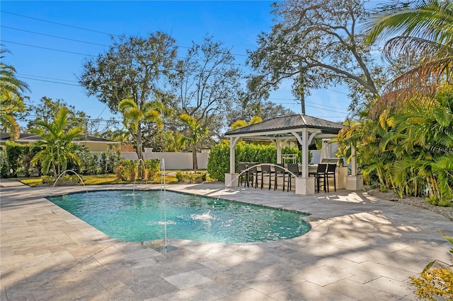 view of pool featuring a gazebo, pool water feature, a patio area, and a bar