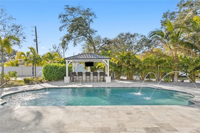 view of swimming pool with pool water feature, a patio, a bar, and a gazebo