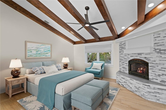 bedroom featuring ceiling fan, light hardwood / wood-style floors, and vaulted ceiling with beams