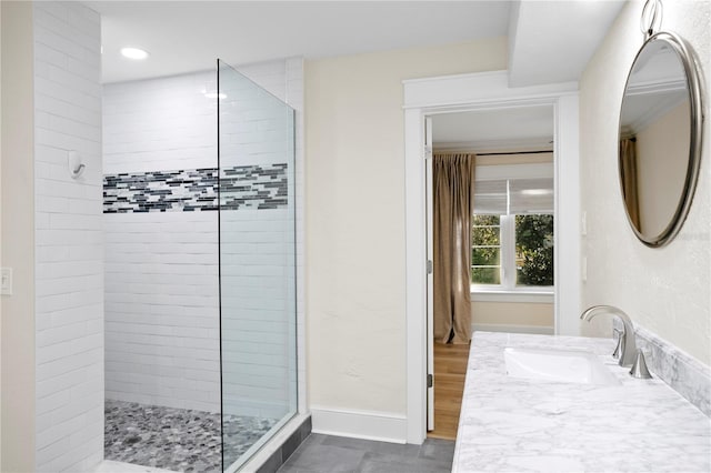 bathroom with vanity and tiled shower