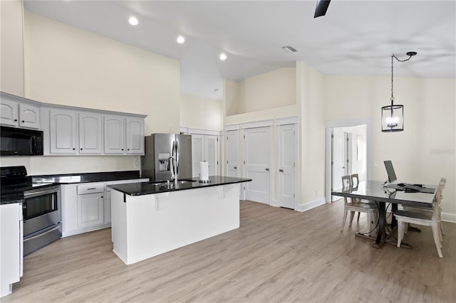 kitchen featuring sink, a center island, appliances with stainless steel finishes, pendant lighting, and light hardwood / wood-style floors