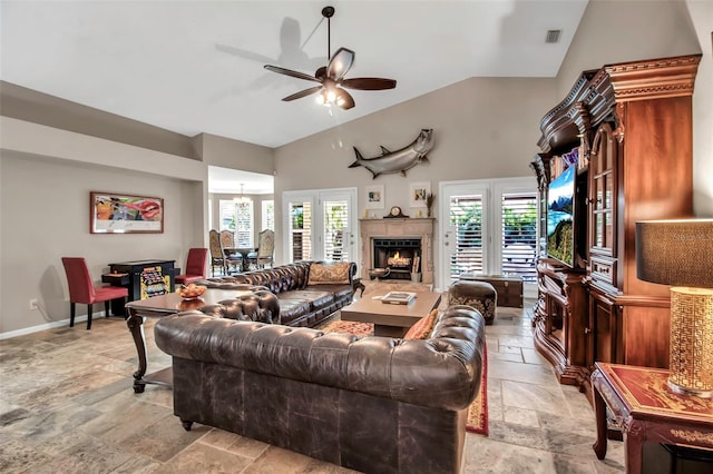 living room with ceiling fan with notable chandelier, high vaulted ceiling, and a healthy amount of sunlight