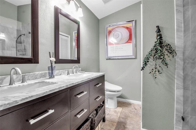 bathroom with lofted ceiling, vanity, and toilet