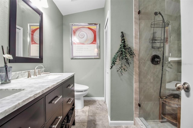 bathroom with lofted ceiling, vanity, toilet, and a tile shower