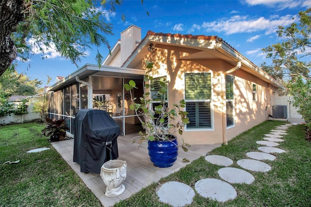 back of house featuring central AC, a yard, a patio, and a sunroom