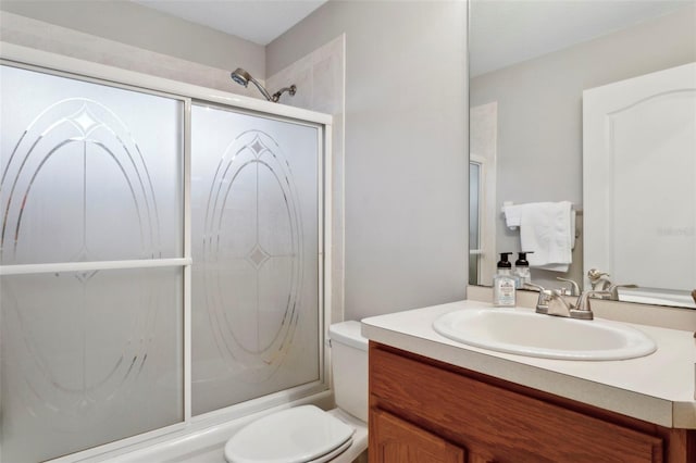 full bathroom featuring enclosed tub / shower combo, vanity, and toilet