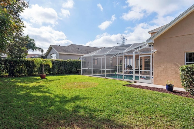 view of yard with a fenced in pool and glass enclosure