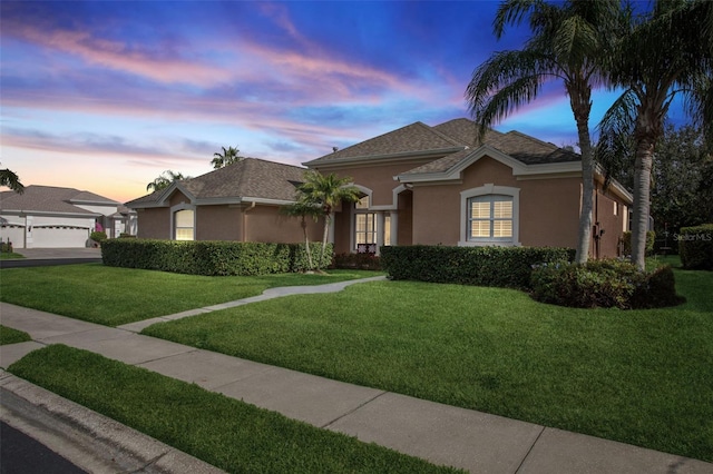 view of front of home featuring a garage and a lawn