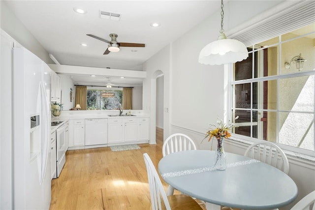 dining space with sink, light hardwood / wood-style floors, and ceiling fan