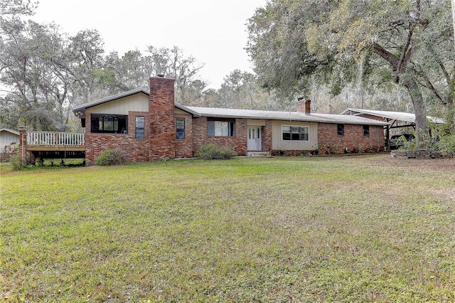 rear view of house featuring a carport and a lawn