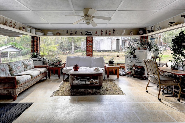 sunroom / solarium with a paneled ceiling and ceiling fan