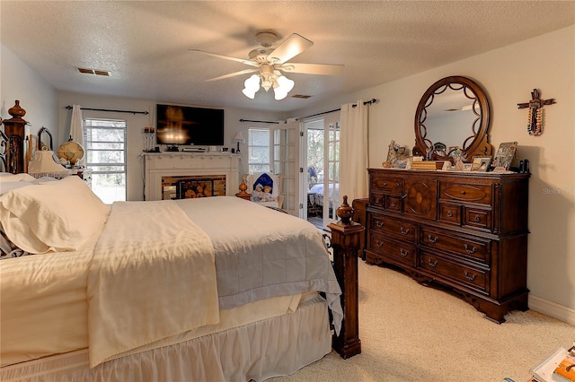 carpeted bedroom featuring ceiling fan, access to exterior, and a textured ceiling