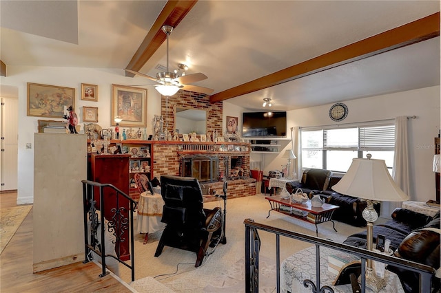 living room featuring brick wall, a fireplace, lofted ceiling with beams, ceiling fan, and light hardwood / wood-style flooring