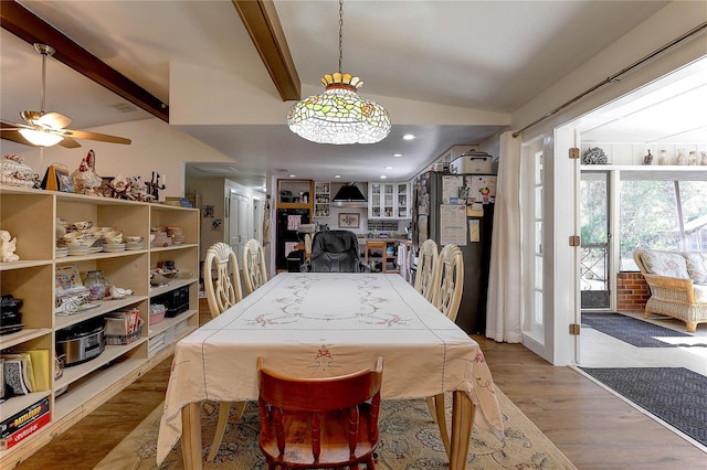 dining room with ceiling fan, light hardwood / wood-style flooring, and beamed ceiling