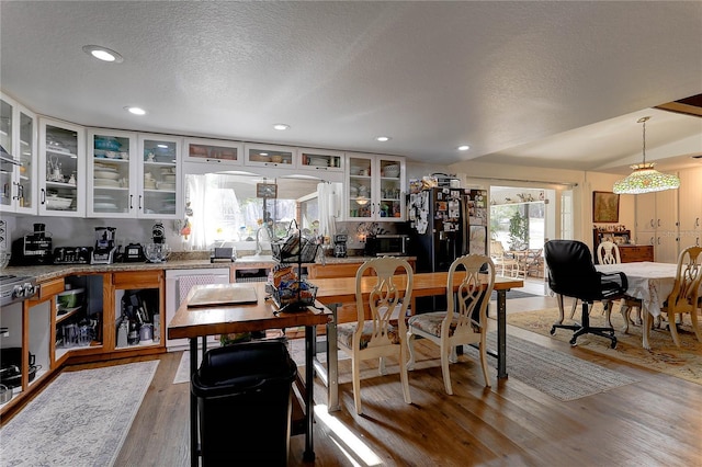 dining space featuring radiator heating unit, hardwood / wood-style floors, and a textured ceiling