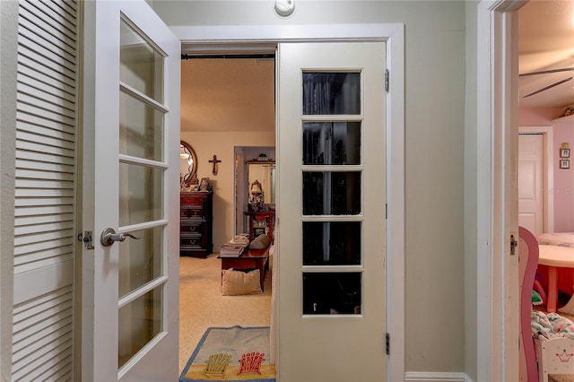 hallway featuring french doors and carpet flooring