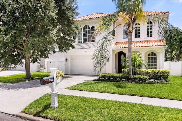 mediterranean / spanish-style house with a garage and a front lawn