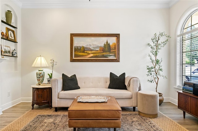 sitting room with hardwood / wood-style flooring and crown molding