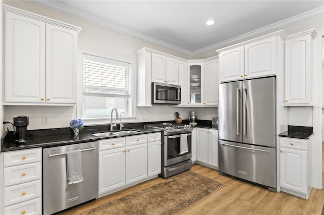 kitchen with dark stone countertops, stainless steel appliances, sink, and white cabinets