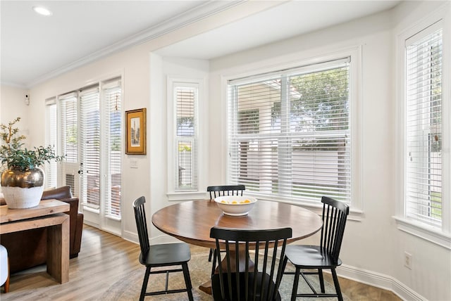 dining room with hardwood / wood-style floors and crown molding