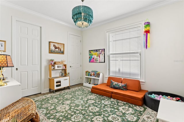 playroom with crown molding, wood-type flooring, and an inviting chandelier