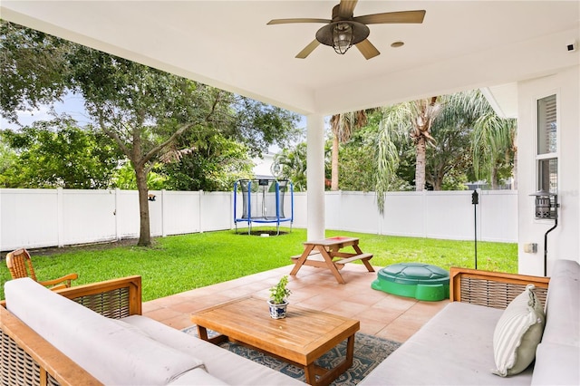 view of patio featuring a trampoline, an outdoor living space, and ceiling fan