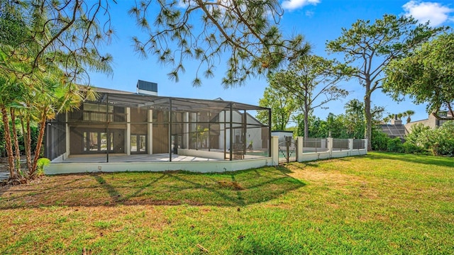 rear view of house with a yard, a patio, and glass enclosure