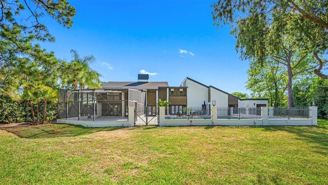 rear view of property with a yard and glass enclosure