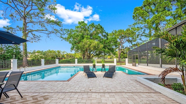 view of pool with a patio area and glass enclosure