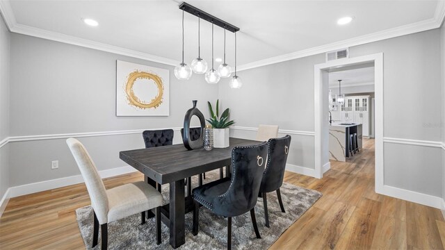 dining room featuring crown molding and light wood-type flooring