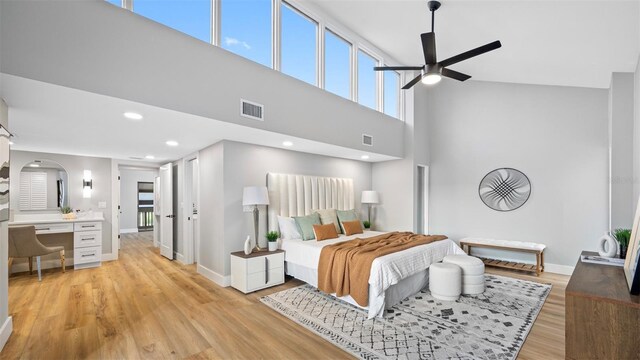 bedroom featuring a towering ceiling and light hardwood / wood-style floors