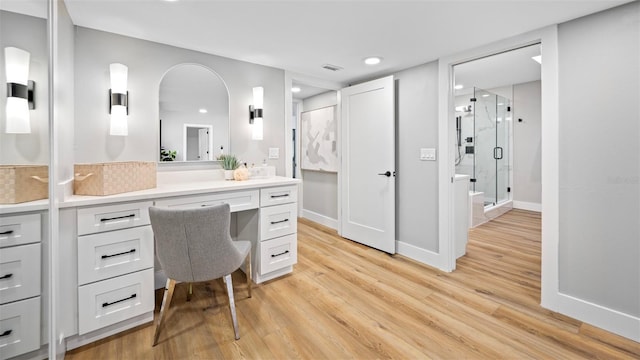 bathroom with vanity, hardwood / wood-style flooring, and a shower with shower door