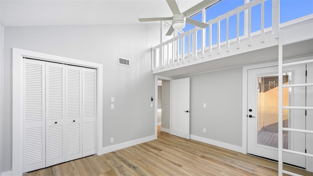 unfurnished bedroom featuring ceiling fan, high vaulted ceiling, light wood-type flooring, and a closet