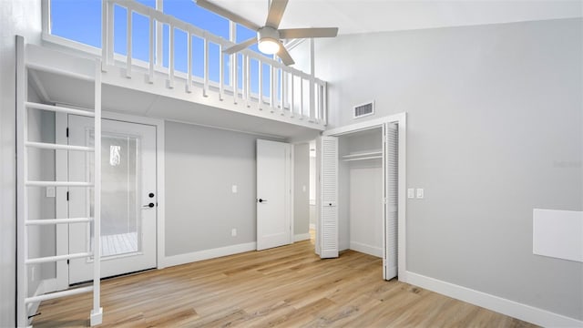 unfurnished bedroom with light hardwood / wood-style floors and a high ceiling