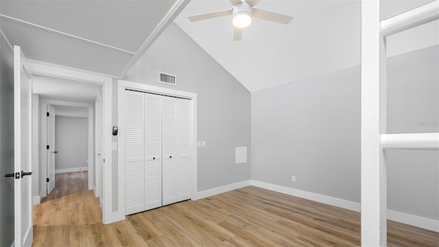 unfurnished bedroom with ceiling fan, lofted ceiling, light wood-type flooring, and a closet