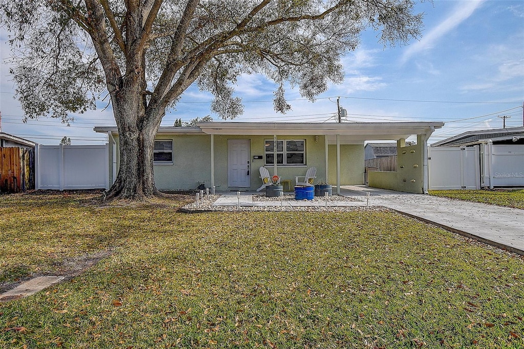 rear view of house featuring a yard and a carport