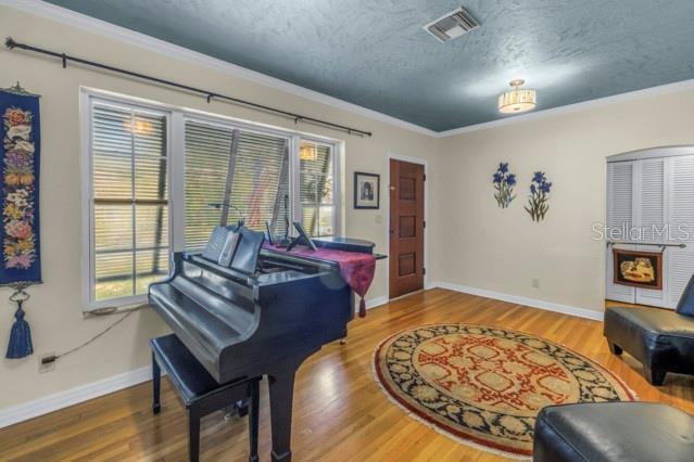 miscellaneous room featuring hardwood / wood-style flooring, a healthy amount of sunlight, and a textured ceiling